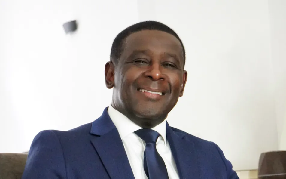 Chérif Adoudou, fondateur de Sine Qua Non conseil, souriant, en costume bleu